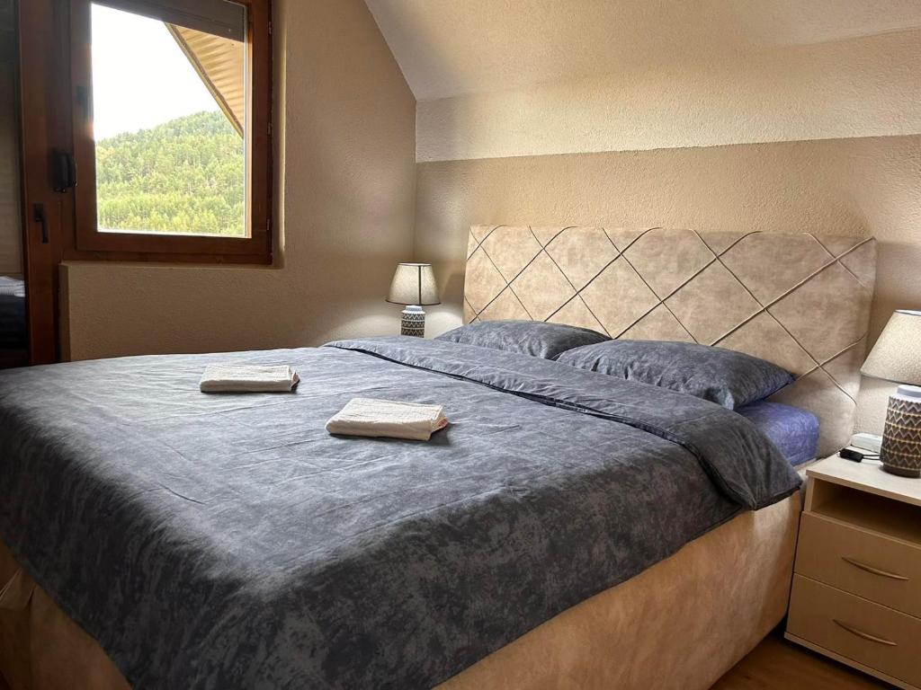 a bedroom with a large bed with two towels on it at Zabljak Durmitor view in Žabljak