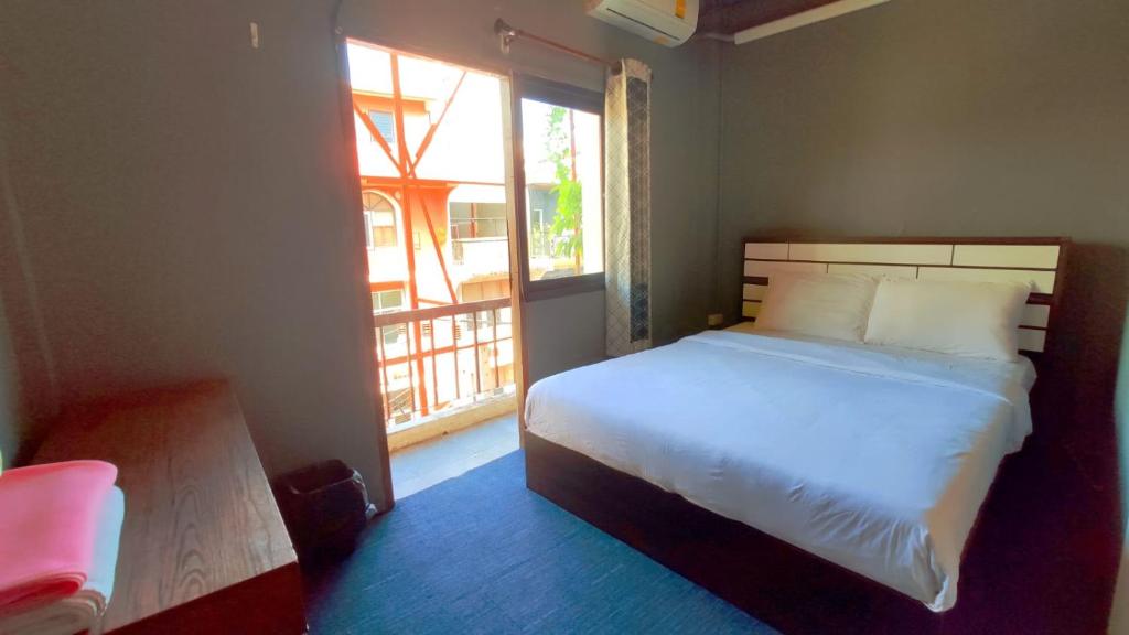 a bedroom with a bed and a large window at Jurockotel in Pattaya Central