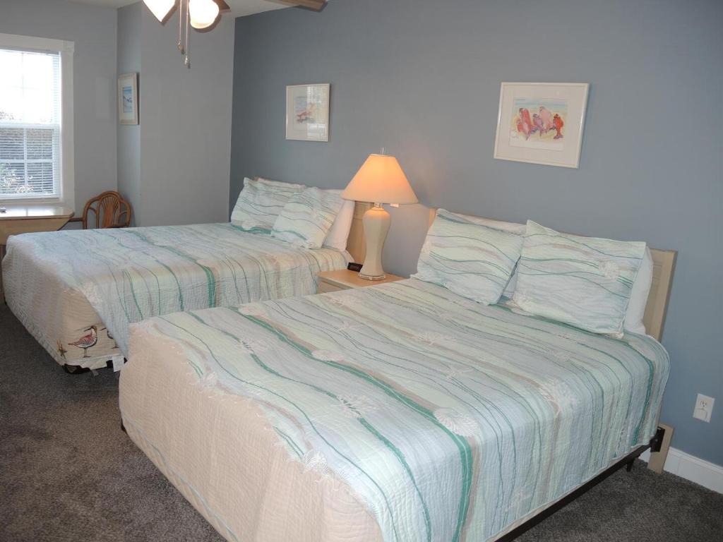 a bedroom with two beds and a lamp on a table at Studio Home 1203L at Brunswick Plantation Resort and Golf Villas in the Heart of NC Seafood Country studio in Calabash