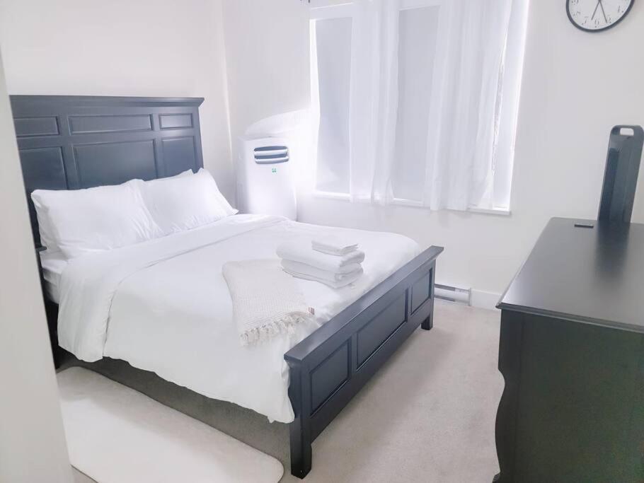 een slaapkamer met een bed met witte lakens en een bureau bij Modern 3Bed-2.5Bath - Delta, BC in Delta