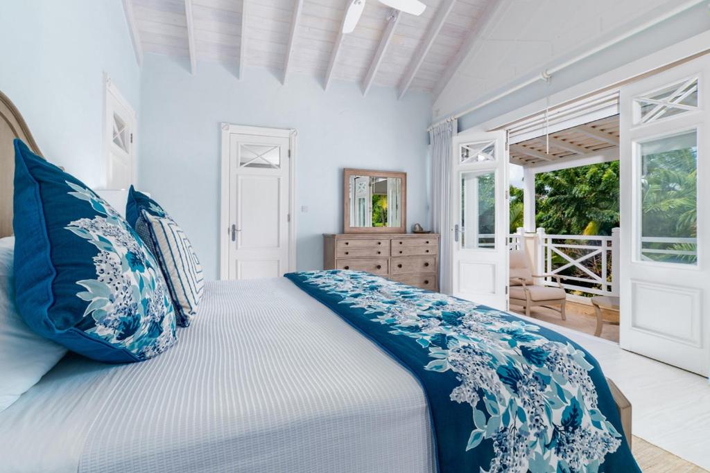 a bedroom with a large bed with blue pillows at Royal Westmoreland - Lime Tree House villa in Saint James