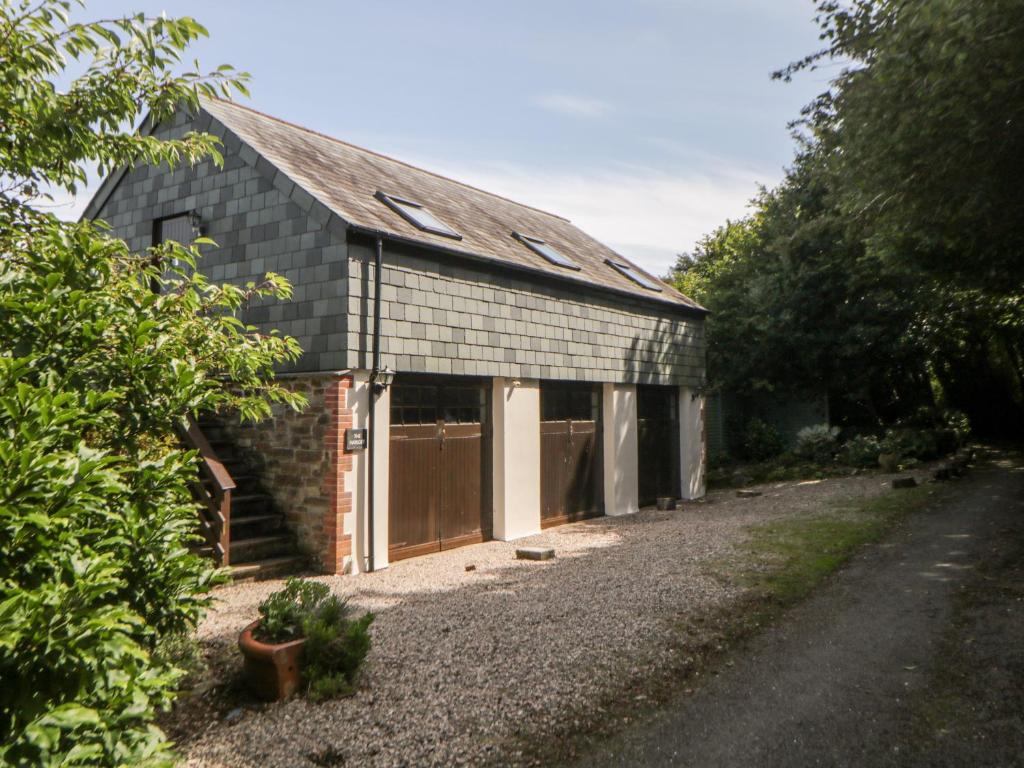a barn with two garage doors and a driveway at The Hayloft in Lostwithiel