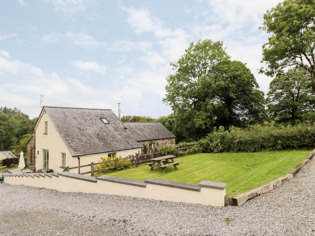 una casa con un patio de hierba delante de ella en Gwyddno Lodge, en Narberth