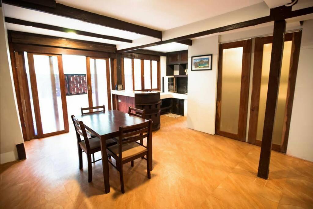 a dining room with a table and chairs and a piano at Apartment Ground floor in El Nido