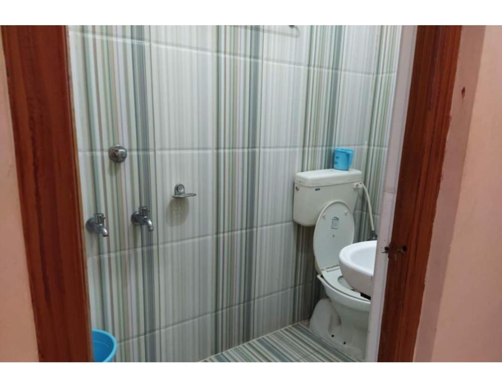 y baño pequeño con aseo y ducha. en Hotel Raj, Chitrakoot en Sītāpur Mūāfi