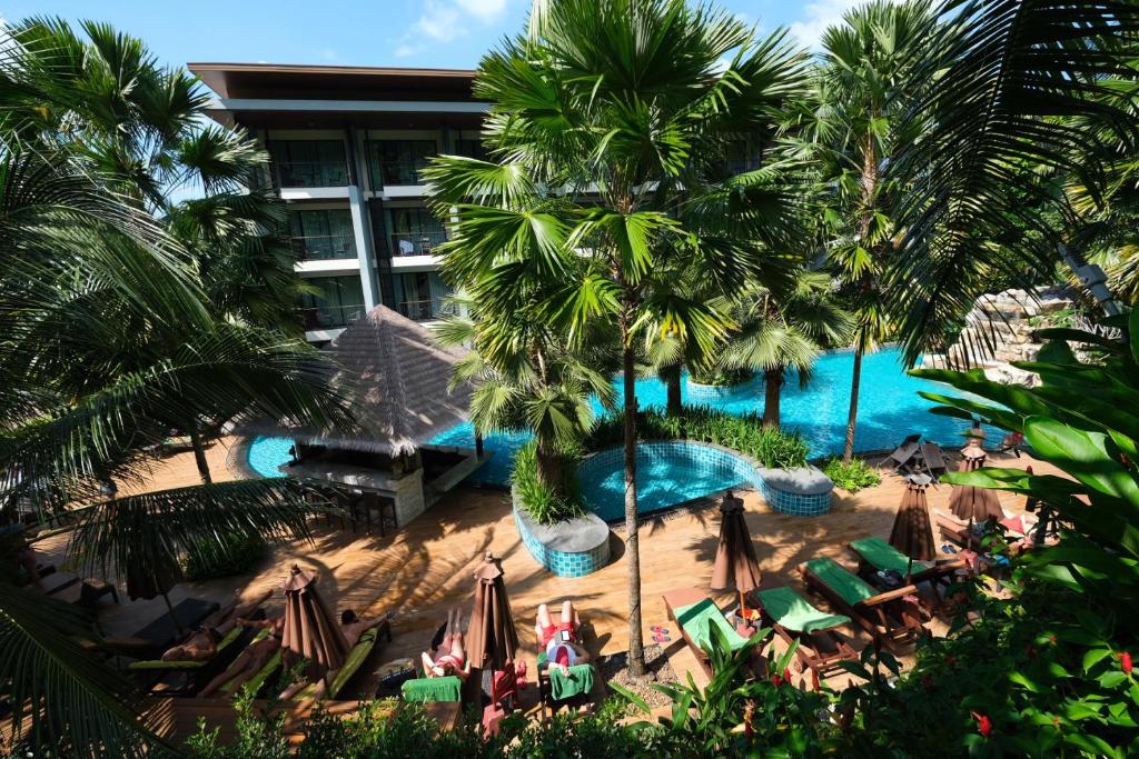 an aerial view of a resort with palm trees and a pool at Hula Hula Resort, Ao Nang -SHA Extra Plus in Ao Nang Beach