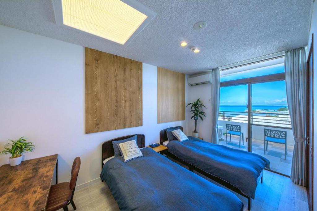 um quarto com 2 camas, uma mesa e uma varanda em Kunigami-gun - House / Vacation STAY 47662 em Onna