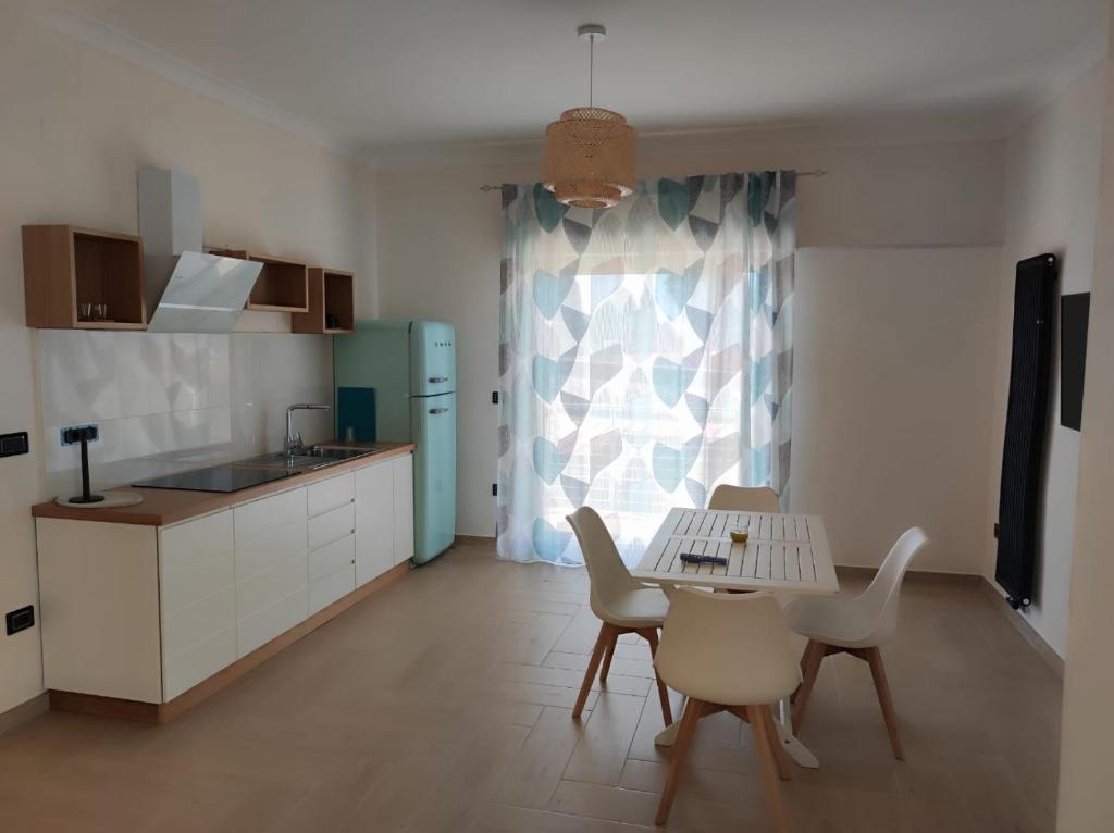 uma cozinha com mesa e cadeiras e uma cozinha com lavatório em Stefanelli Tropea Home em Tropea