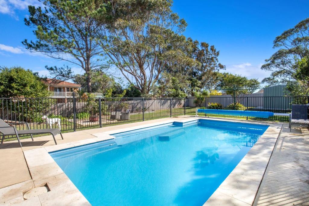 a swimming pool in a yard with a fence and trees at Pipers Spot - Pet Friendly - Fireplace with Swimming Pool in Culburra Beach