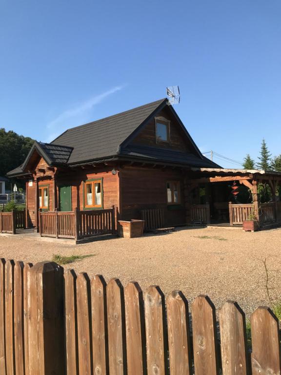 una casa de madera con una valla delante en Domek w Dolinie Bałtów, en Bałtów