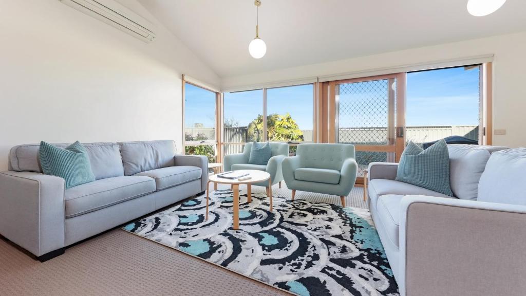 a living room with two couches and a table at Oyster View in Merimbula