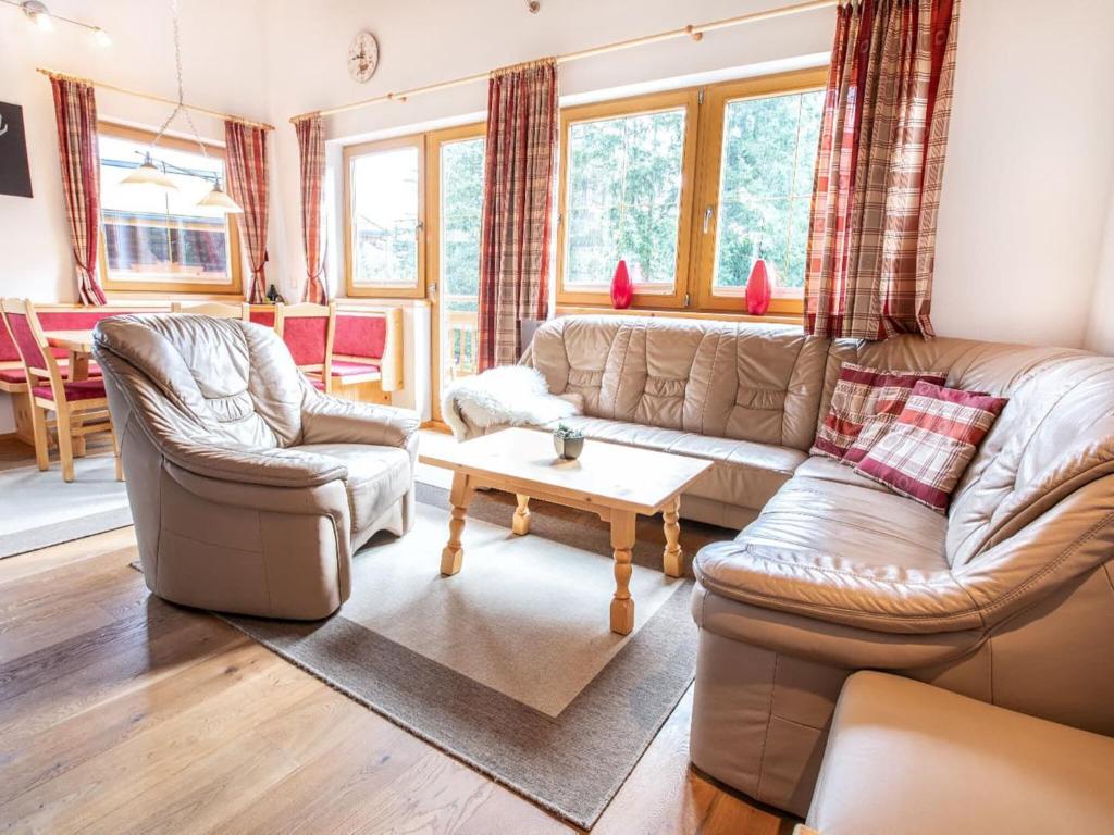 a living room with a couch and two chairs and a table at Chalet Hochkrimml with sauna on the ski slope in Nothdorf
