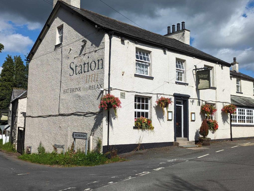 a white building on the corner of a street at Station Inn in Kendal