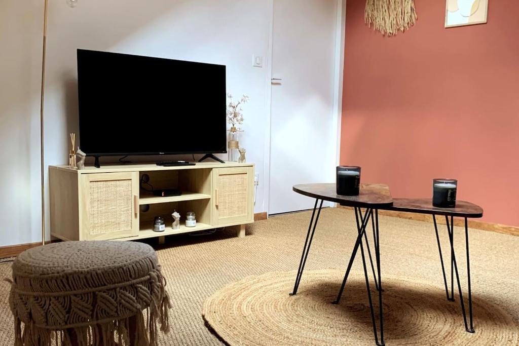 a living room with a tv and a table at La Bohè’m night in Villeneuve-la-Guyard