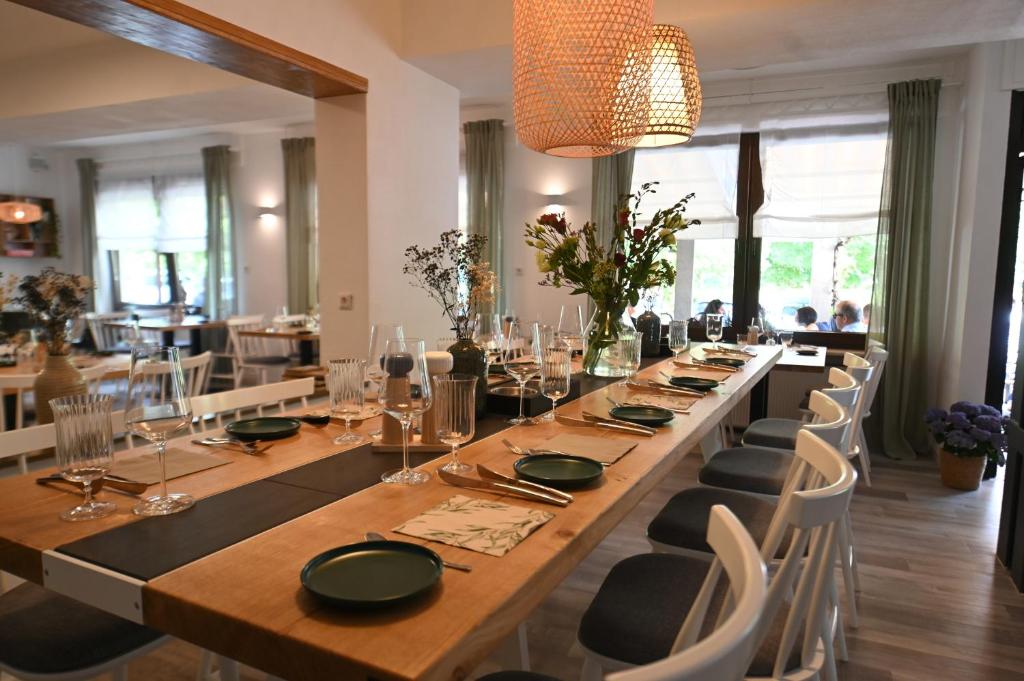 einen langen Tisch mit Stühlen und einen langen Tisch mit Brille in der Unterkunft Ley Hotel in Klotten