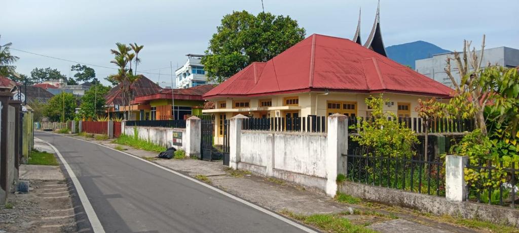 a house with a red roof on the side of a road at PONDOK SITI RAWIYAH in Bukittinggi