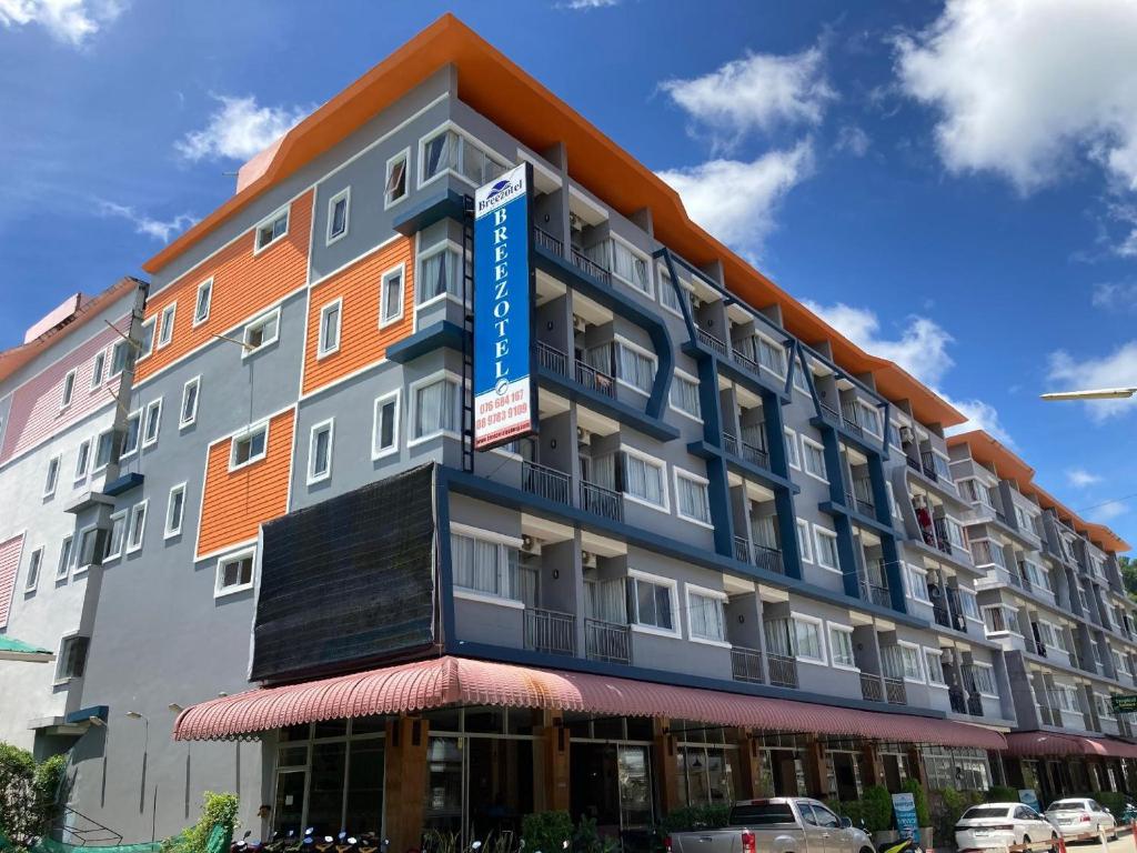 a building with a blue sign on the side of it at Breezotel - SHA Certified in Patong Beach