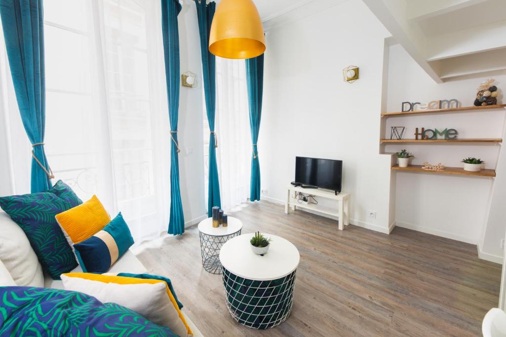 un salon avec un canapé et une télévision dans l'établissement Loft Latin, à Paris