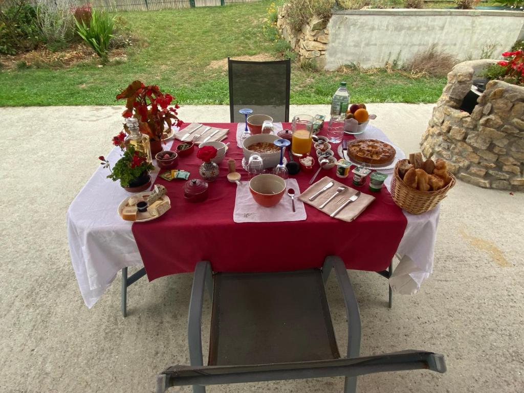 une table avec un tissu de table rouge et de la nourriture dans l'établissement Chambre douillette, calme, lit queen size wifi, à Avrillé