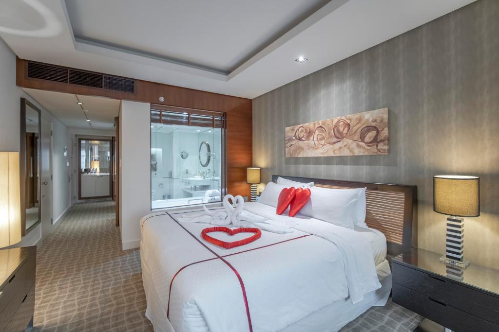 a bedroom with a large white bed with a heart on it at Majestic Premier Hotel Burdubai in Dubai
