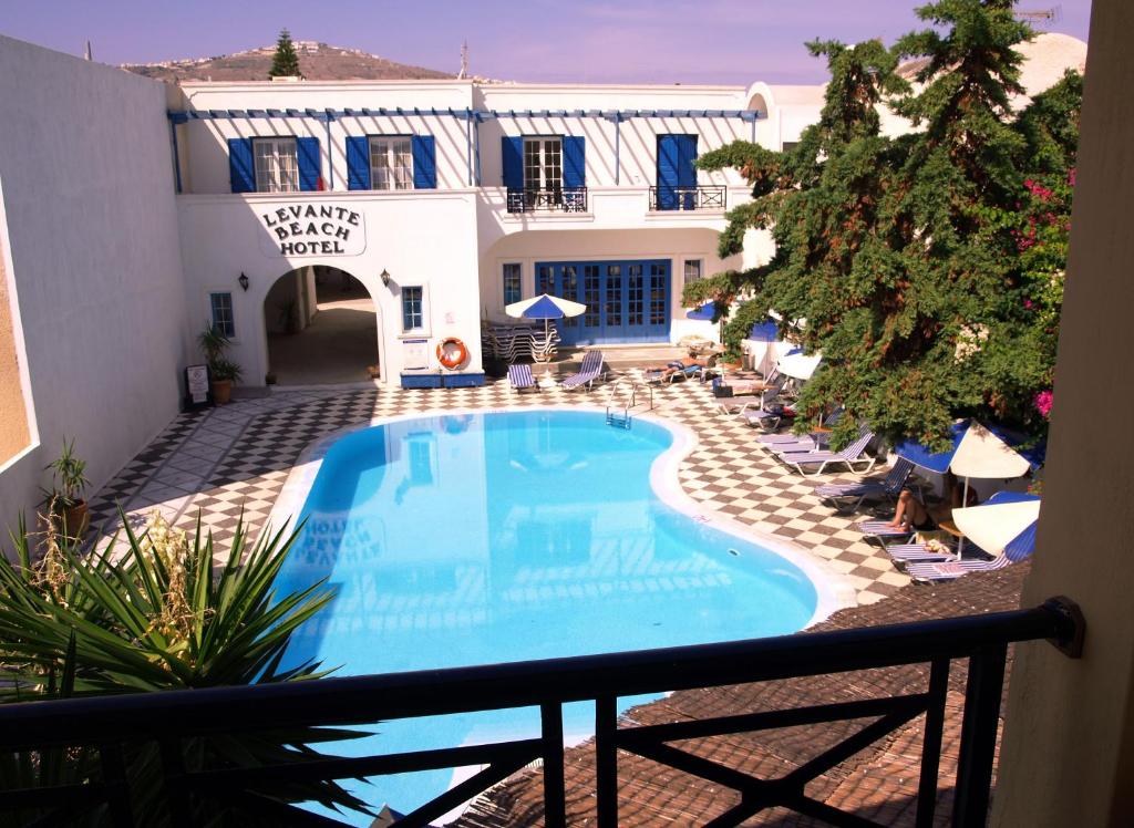 balcone con vista sulla piscina di un hotel di Levante Beach Hotel a Kamari
