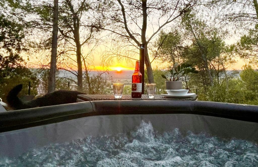 un chien assis dans une baignoire avec une table et une boisson dans l'établissement Studio du Roc des Garrigues, à Langlade