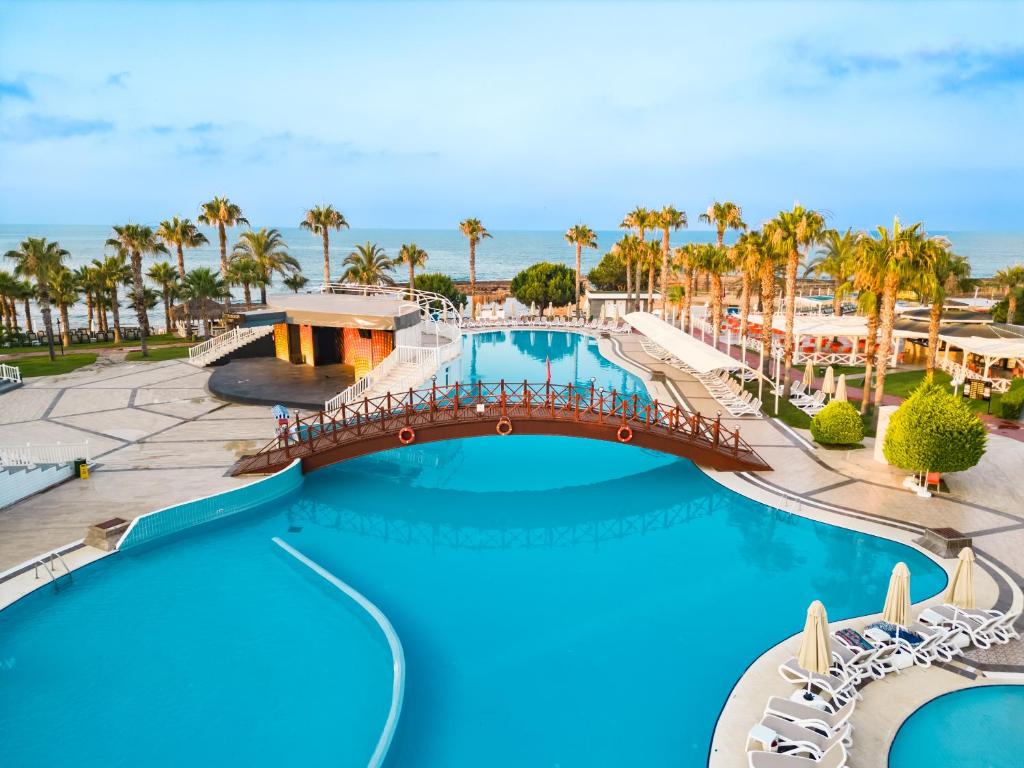 Oz Hotels Incekum Beach في ألانيا: اطلالة المسبح في منتجع فيه نخيل