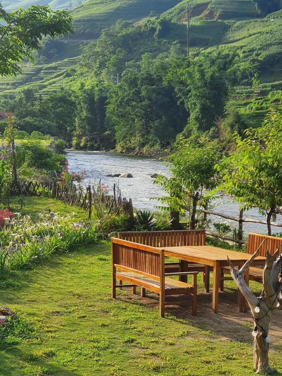 a wooden picnic table sitting next to a lake at Deja Vu Sapa Homestay in Sapa