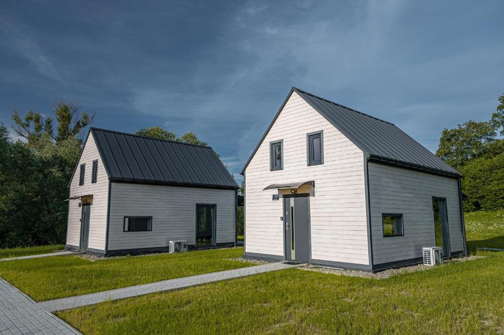 duża, biała stodoła z czarnym dachem w obiekcie Łąckie Zacisze w Łącku