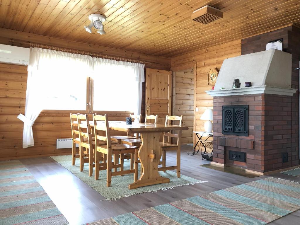 a dining room with a table and a fireplace at Katriina, huom! sijaitsee saaressa, locates on island in Tahkovuori