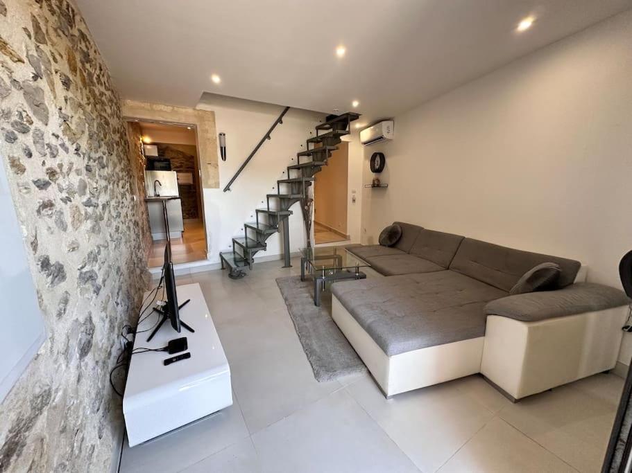 un salon avec un canapé et un escalier dans l'établissement L’élégance de la pierre, à Fourques