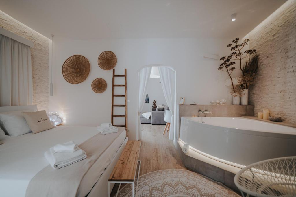 ein Schlafzimmer mit einer Badewanne, einem Bett und einer Badewanne in der Unterkunft M’ami in San Cassiano