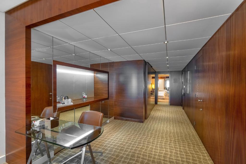 an office with a glass table and chairs in a hallway at Majestic Premier Hotel Burdubai in Dubai