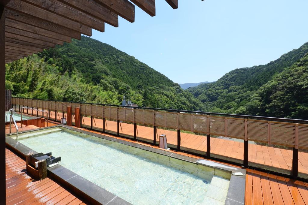 a swimming pool on a deck with mountains in the background at Sansuirou in Yugawara