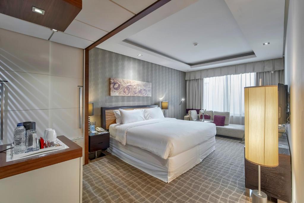 a hotel room with a bed and a living room at Majestic Premier Hotel Burdubai in Dubai
