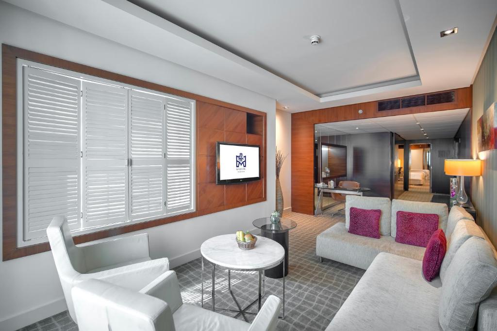 a living room with a couch and a table at Majestic Premier Hotel Burdubai in Dubai