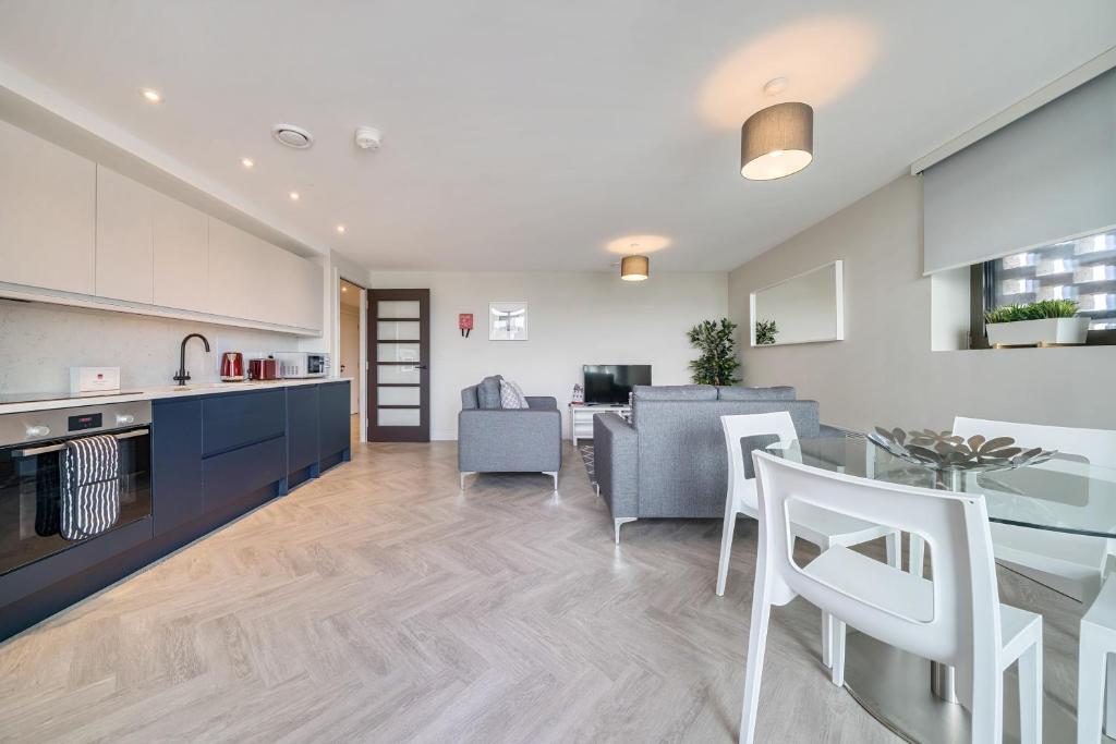 cocina y sala de estar con mesa y sillas en Roomspace Serviced Apartments- Buttermere House en Kingston upon Thames