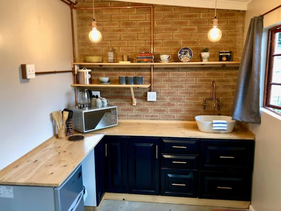 a kitchen with a counter top with a microwave at Modern Industrial Cottage in Kingsburgh