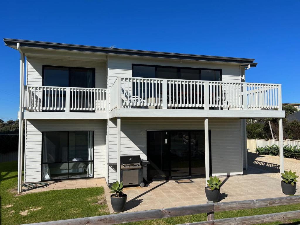 a white house with a balcony and a patio at ACACIA - 6 Joy Tce Pets Welcome outside in Robe