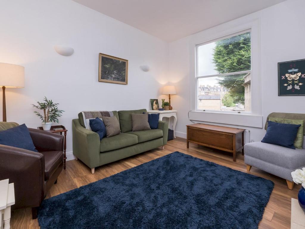 uma sala de estar com dois sofás e um tapete azul em Pass the Keys Stylish apartment in Central Bath em Bath