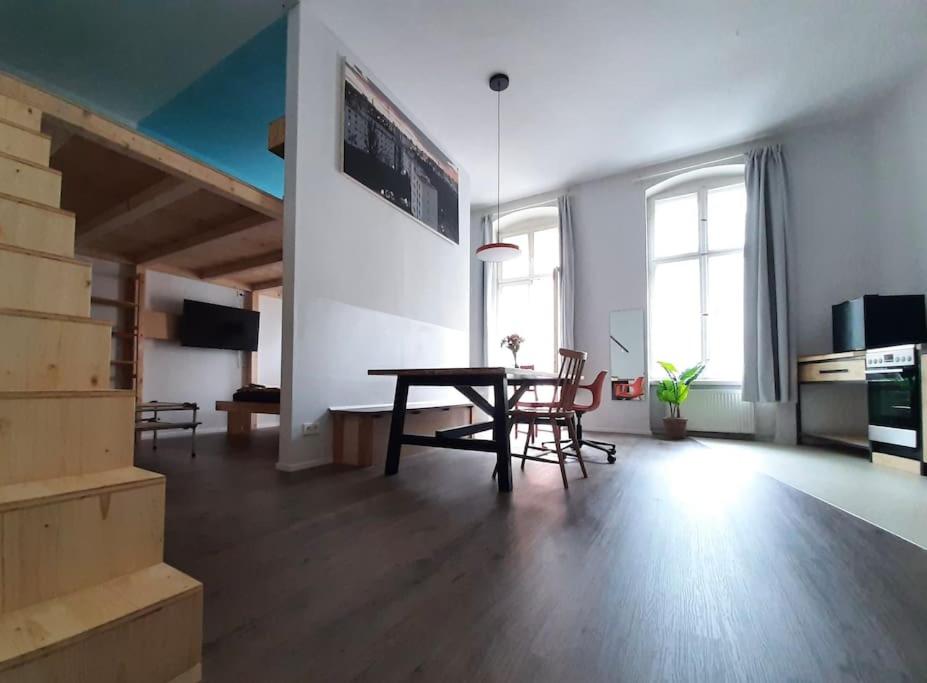 ein Wohnzimmer mit einem Holztisch und Stühlen in der Unterkunft Artist Studio - Berlin - Prenzlauer Berg in Berlin