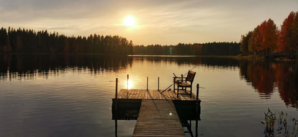 a chair sitting on a dock on a lake at Mäntyniemi in Petäjävesi