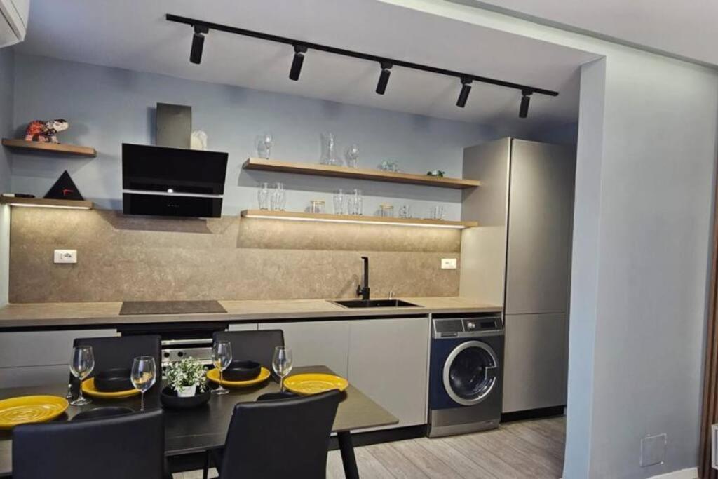 a kitchen with a table and chairs and a washer and dryer at City Center Apartment in Tirana