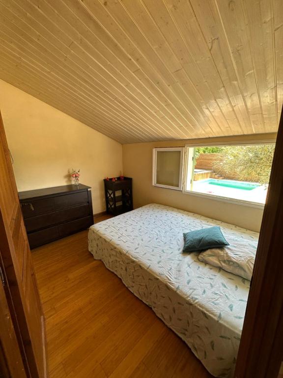 um pequeno quarto com uma cama e uma janela em Dépendance Tulum em Cabriès