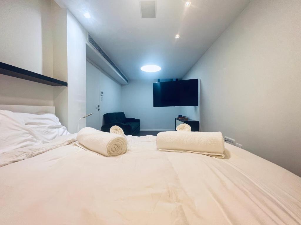 1 dormitorio con 1 cama blanca grande y 2 almohadas en Buchman Cozy 1Bedroom Haven, en Modi'ín