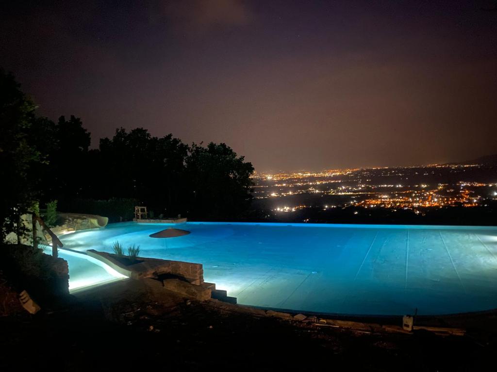 duży basen oświetlony w nocy w obiekcie Camping Barco Reale w mieście Lamporecchio