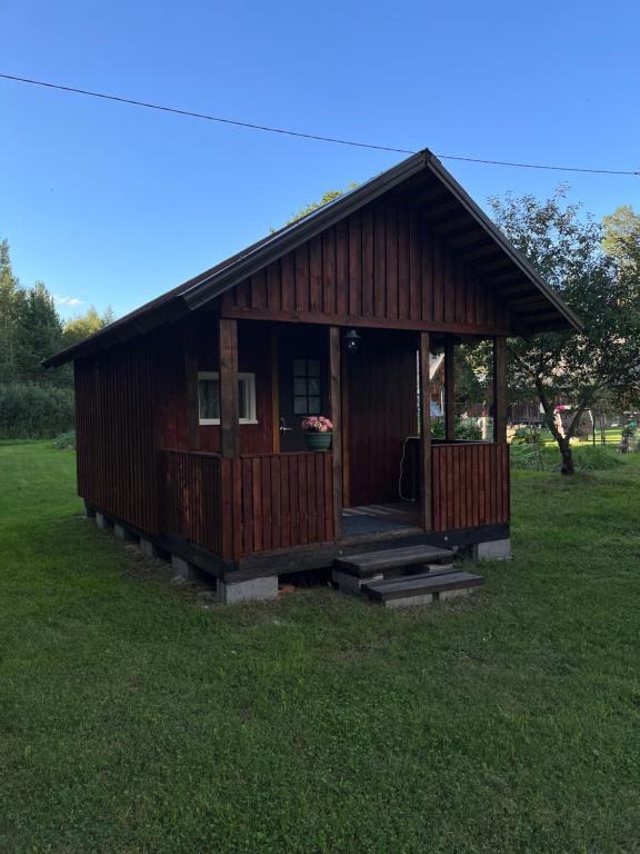 una pequeña cabaña de madera en un campo de hierba en Metsamajake Värskas en Värska