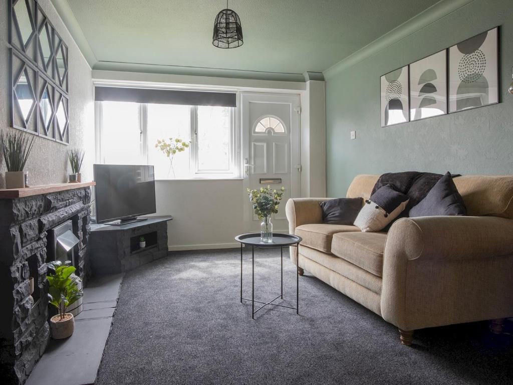 a living room with a couch and a tv at Pass the Keys Comfortable flat in Scunthorpe