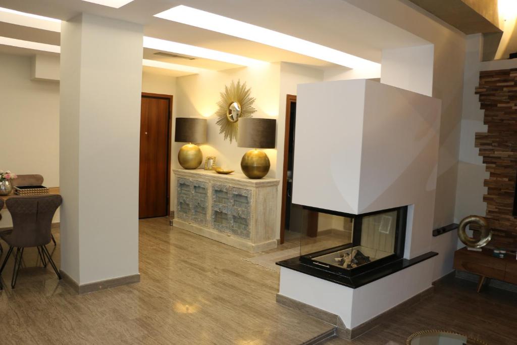 - un salon avec une cheminée et une table dans l'établissement Exzellent ApartAthens 120qm, near Metro M2, à Athènes