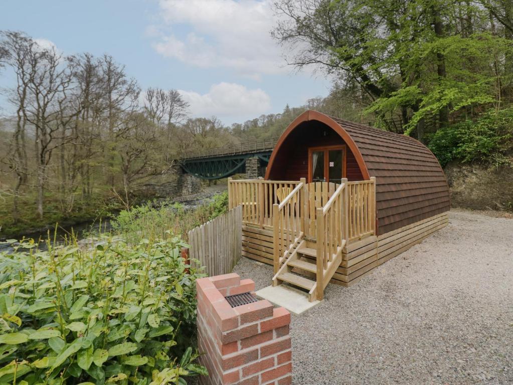 eine kleine Holzhütte mit einer Treppe im Garten in der Unterkunft Pod No 28 in Keswick